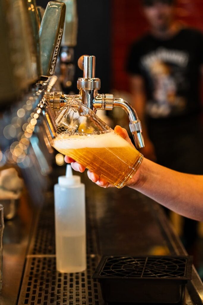 pexels-photo-29290421 Close-up of frothy craft beer being poured from tap in Montreal pub.